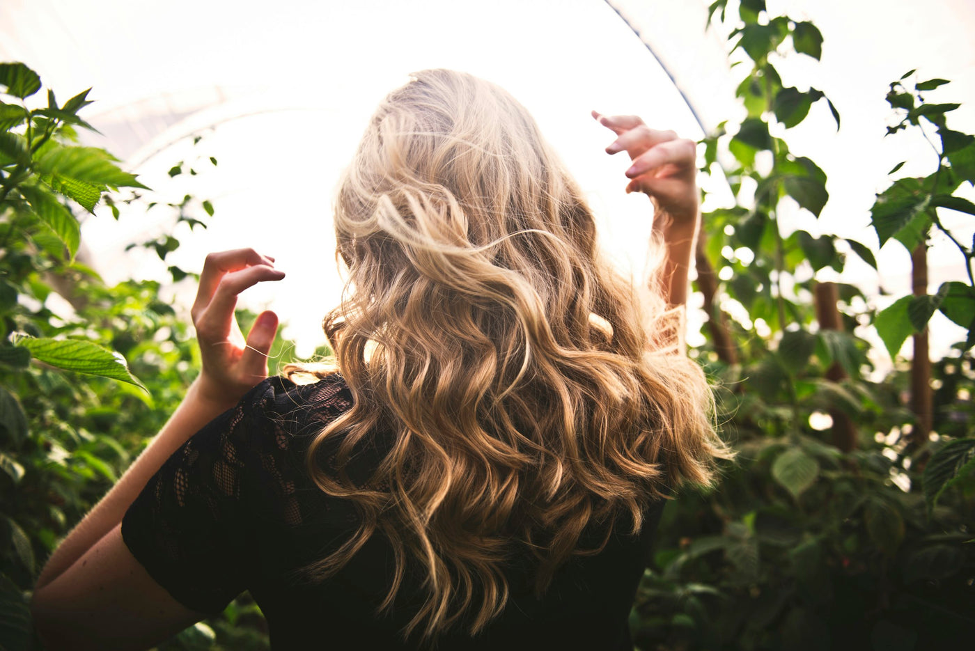 Cheveux ondulés au milieu des plantes